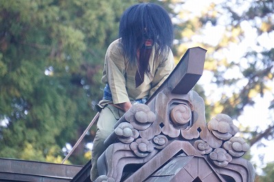 a strange being is  on a roof of shrine